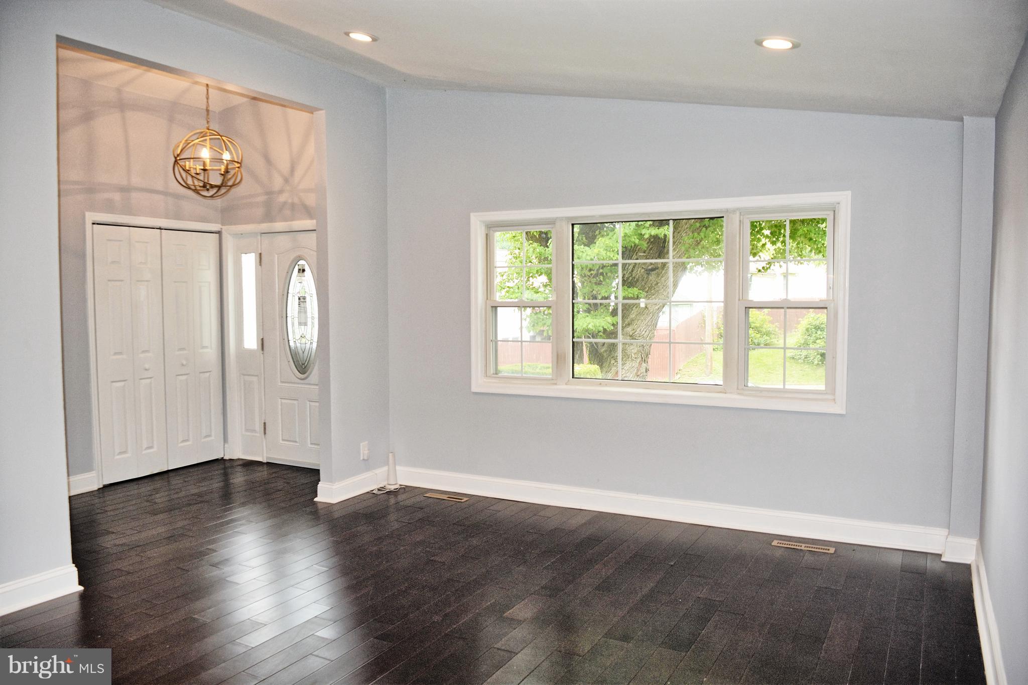 4716 Bonnie Brae Road Baltimore, MD 21208 - Photo 3 of 15 an empty room with wooden floor and windows