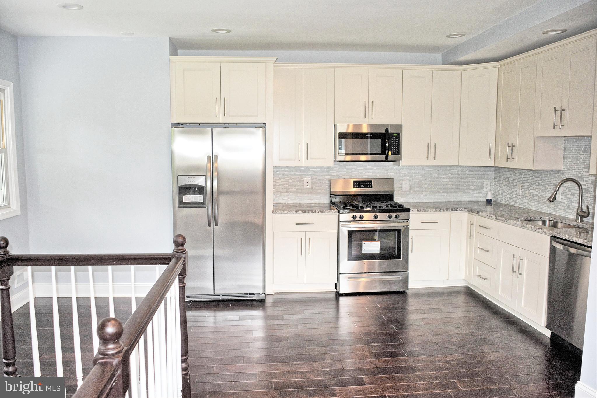 4716 Bonnie Brae Road Baltimore, MD 21208 - Photo 6 of 15 a kitchen with white cabinets and stainless steel appliances