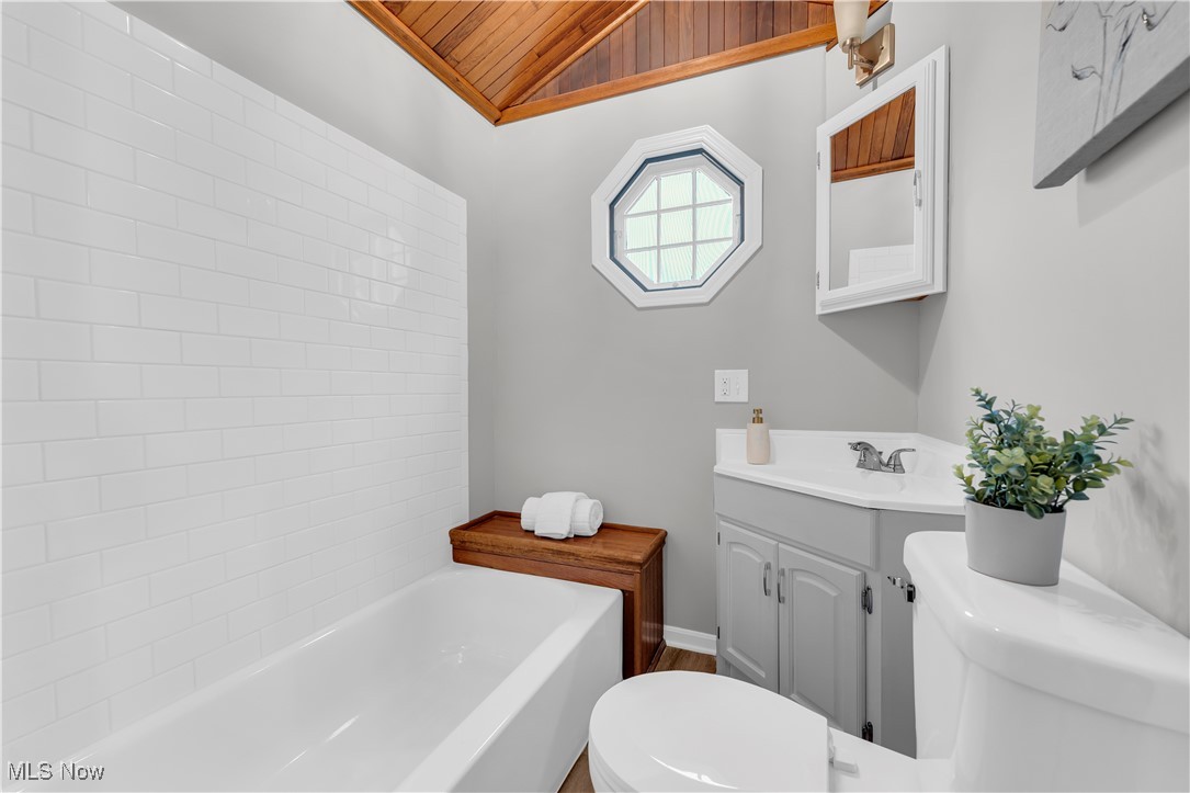 6920 Joppa Road Vermilion, OH 44089 - Photo 22 of 38 Bathroom featuring wood ceiling, vanity, lofted ceiling, toilet, and a tub