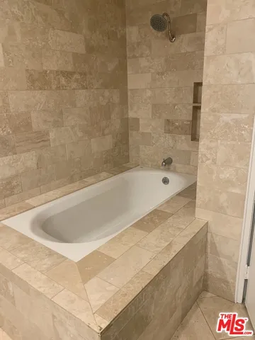 a spacious bathroom with a bathtub and shower