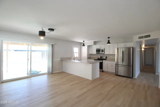 a kitchen with a refrigerator and a stove top oven