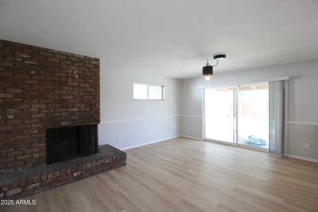 a view of an empty room with a fireplace and a window