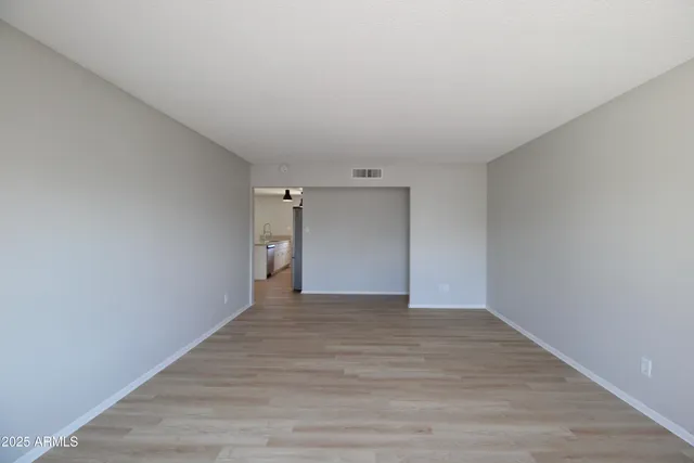 a view of an empty room with wooden floor