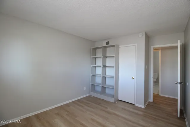 a view of empty room with wooden floor and empty shelves