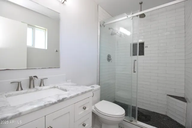a bathroom with a granite countertop sink toilet and shower