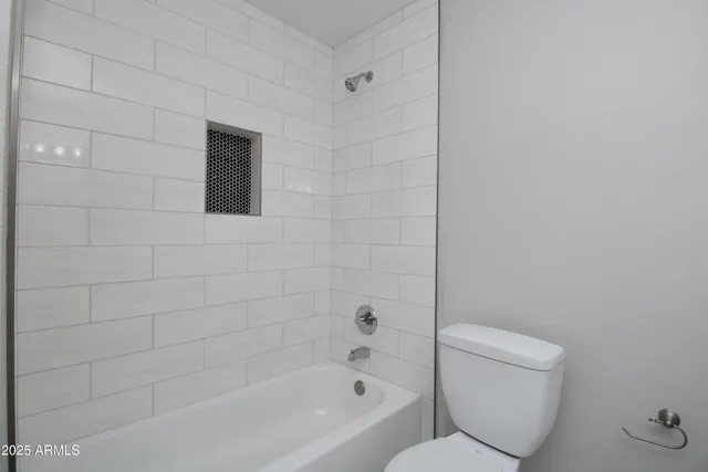 a bathroom with a toilet and bathtub