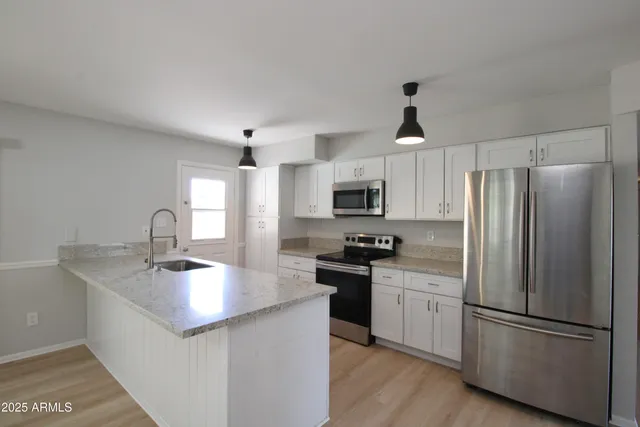 a kitchen with stainless steel appliances granite countertop a sink stove and refrigerator