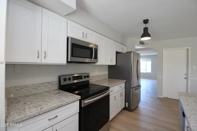a kitchen with stainless steel appliances granite countertop a sink stove and refrigerator