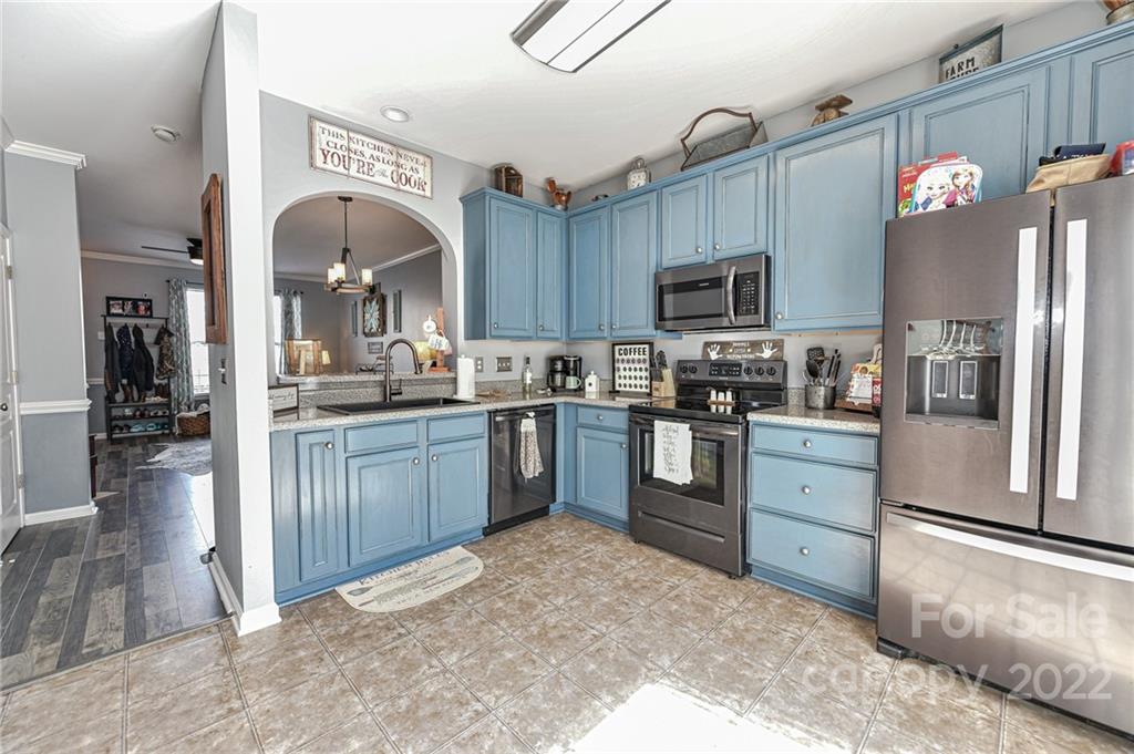 122 Chimney Rock Lane Fort Mill, SC 29708 - Photo 11 of 27 a kitchen with granite countertop a refrigerator oven a sink dishwasher and a stove with wooden cabinets