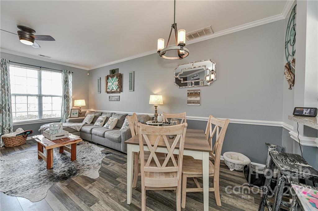 122 Chimney Rock Lane Fort Mill, SC 29708 - Photo 8 of 27 a view of a dining room with furniture a chandelier and wooden floor