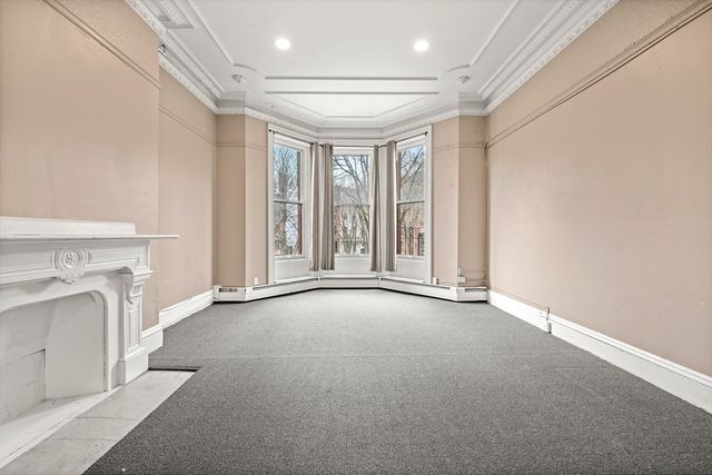 a view of an empty room with a fireplace and a window