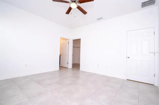 an empty room with a empty space and a ceiling fan
