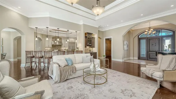 a view of a dining room with furniture a chandelier and wooden floor