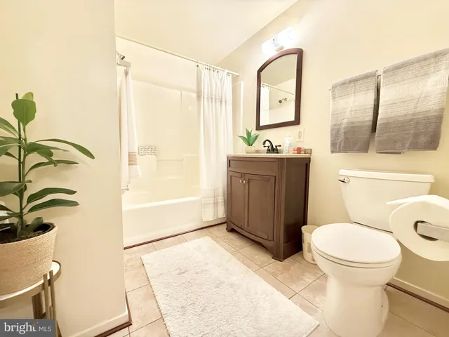 a kitchen with stainless steel appliances kitchen island granite countertop a refrigerator a sink dishwasher and white cabinets with wooden floor