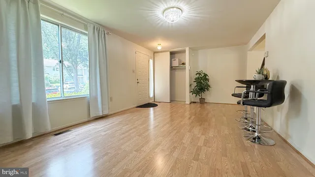 a view of an empty room with wooden floor and stairs