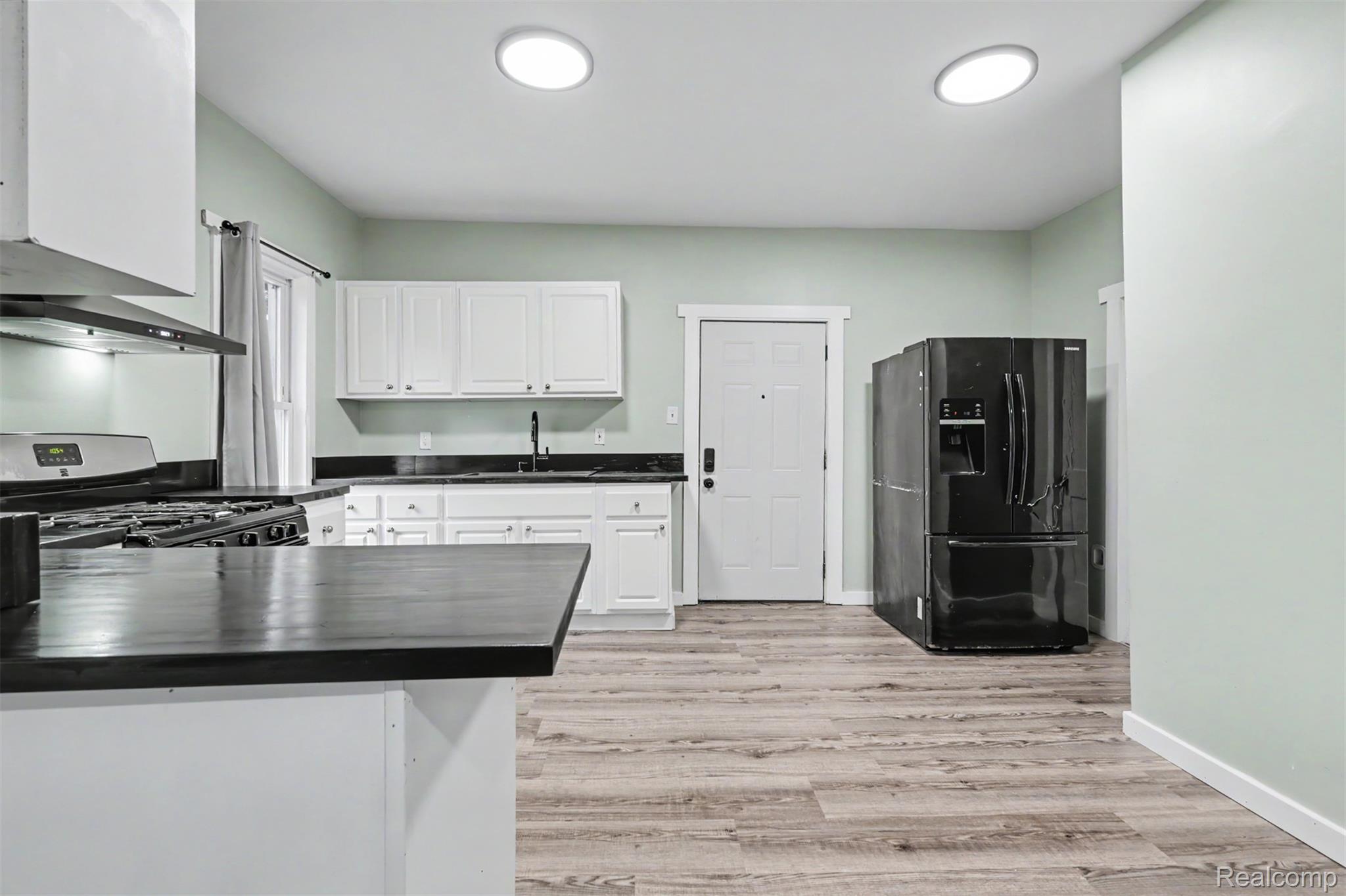 8397 Lane Street Detroit, MI 48209 - Photo 10 of 41 Kitchen featuring wood-finish flooring, white cabinetry, dark countertops, and recessed lighting