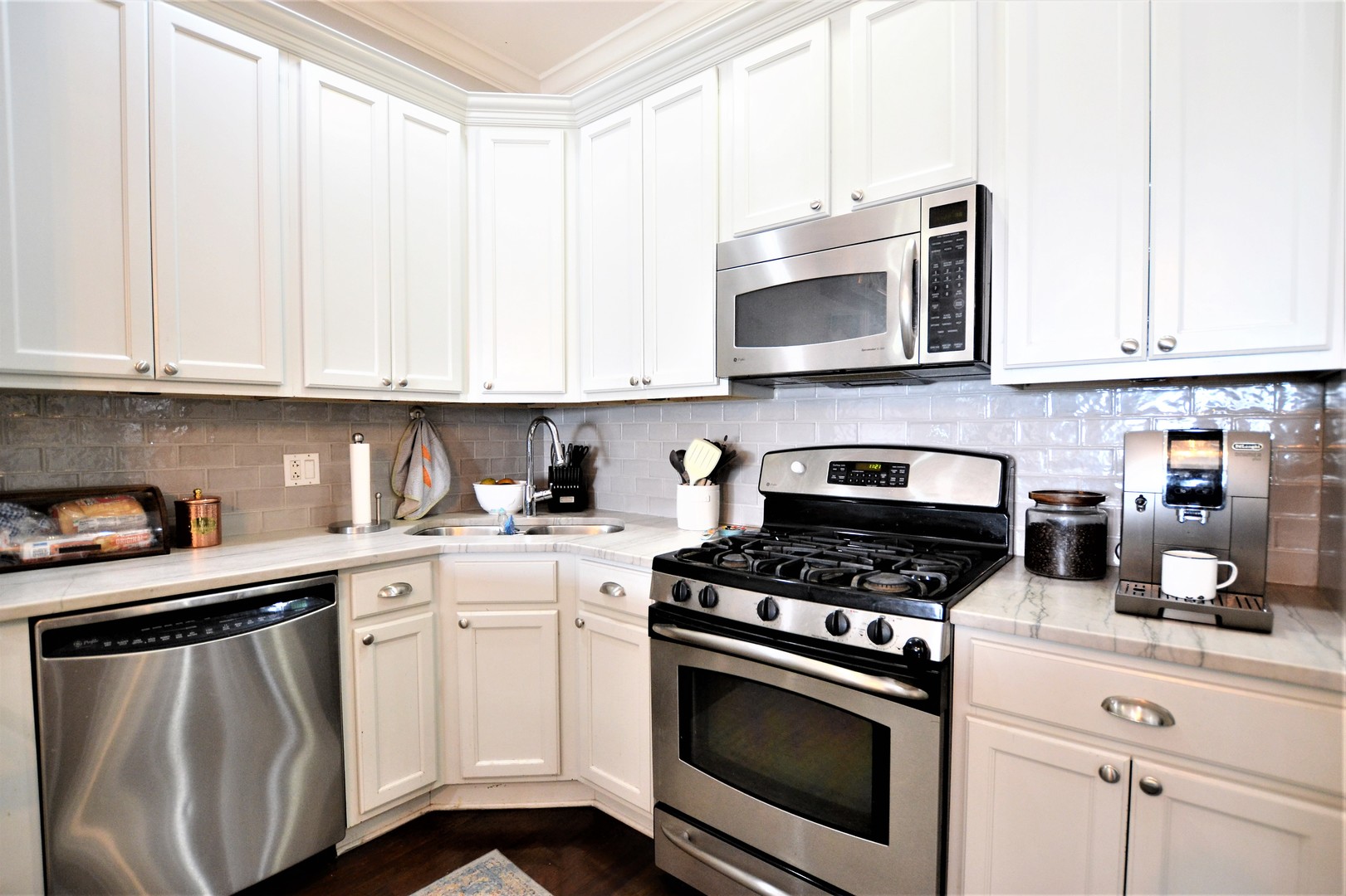 2900 West Irving Park Road, Unit 404 Chicago, IL 60618 - Photo 12 of 26 a kitchen with stainless steel appliances granite countertop a sink a stove and microwave