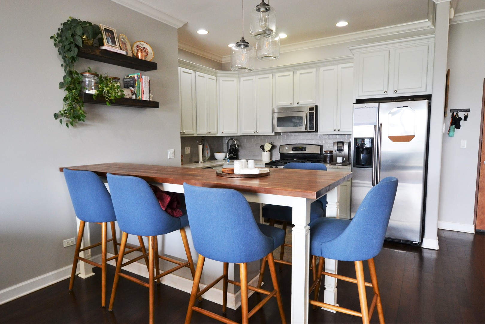 2900 West Irving Park Road, Unit 404 Chicago, IL 60618 - Photo 9 of 26 a kitchen with stainless steel appliances granite countertop a dining table chairs refrigerator and microwave
