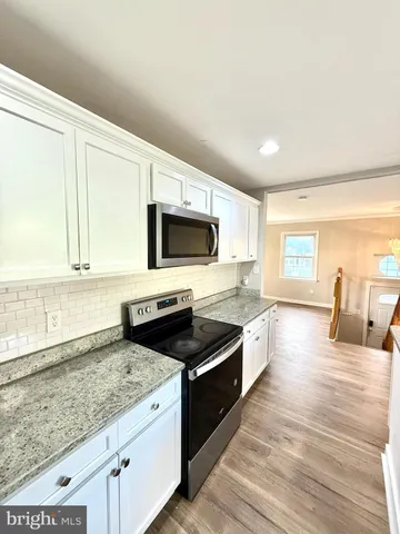 a kitchen with granite countertop wooden cabinets and a stove