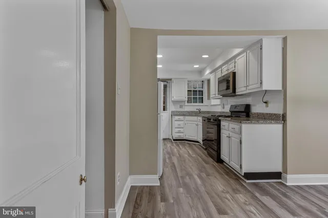 a kitchen with white cabinets and white appliances