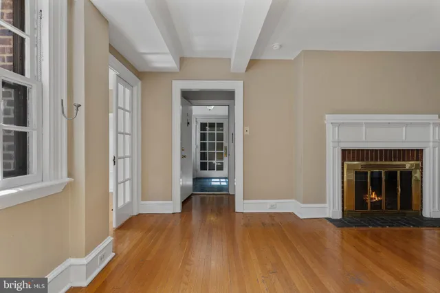 a view of a livingroom with wooden floor and a fireplace