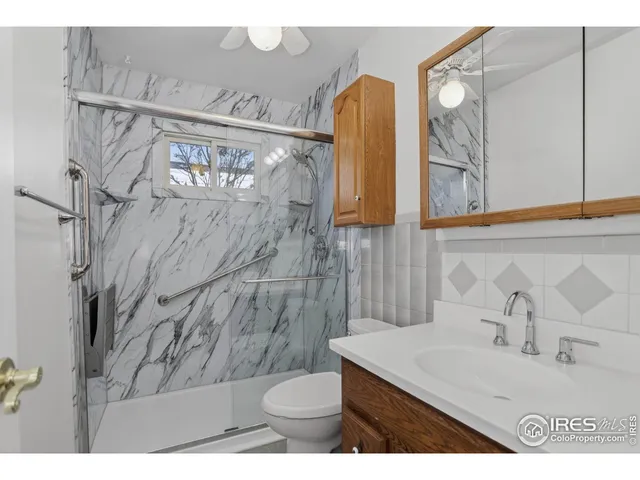 a bathroom with a sink vanity mirror and toilet