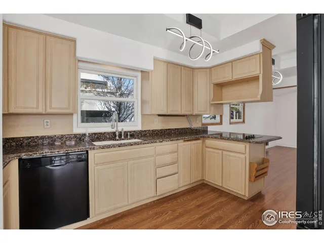 a kitchen with granite countertop a sink stainless steel appliances and cabinets