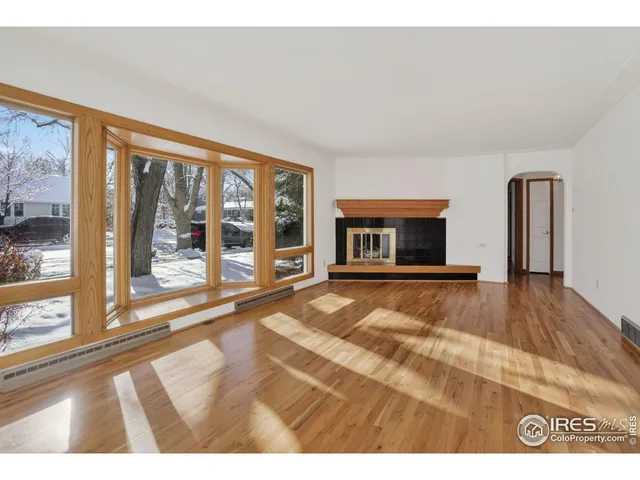 a view of an empty room with a fireplace and a large window