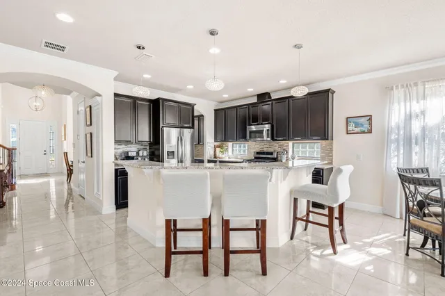 a kitchen with kitchen island granite countertop wooden cabinets and stainless steel appliances