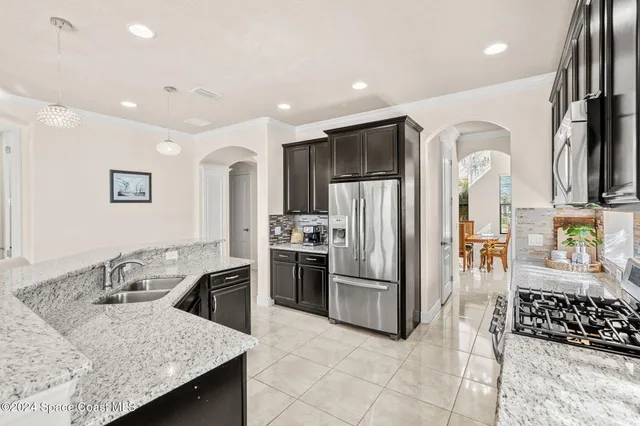 a kitchen with stainless steel appliances granite countertop a sink refrigerator and cabinets