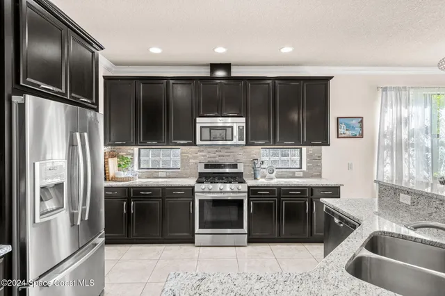 a kitchen with stainless steel appliances granite countertop a refrigerator and a sink