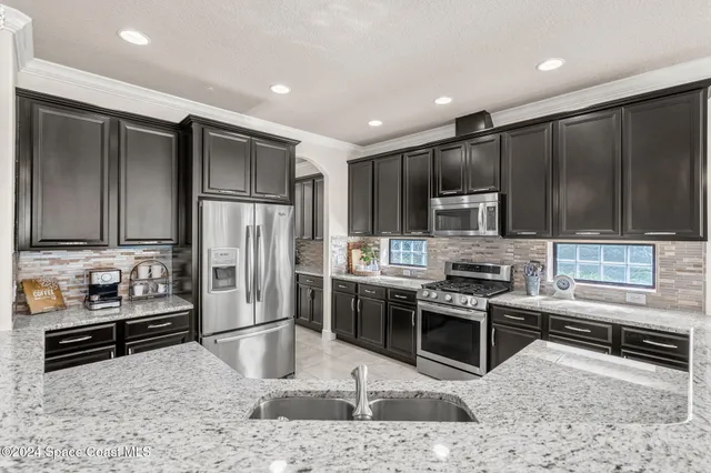 a kitchen with stainless steel appliances wooden cabinets and a stove top oven