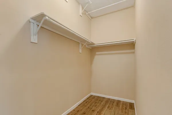 a view of walk in closet with empty racks