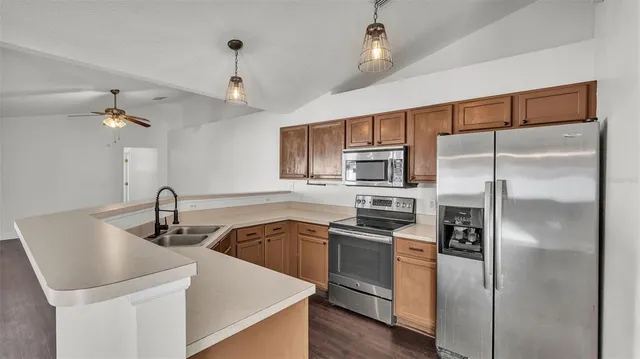 a kitchen with stainless steel appliances granite countertop a sink stove and refrigerator
