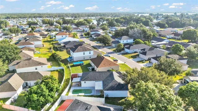 an aerial view of residential houses with outdoor space and swimming pool