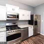 4012 Boarman Avenue Baltimore, MD 21215 - Photo 17 of 43 a kitchen with stainless steel appliances a stove a microwave and cabinets