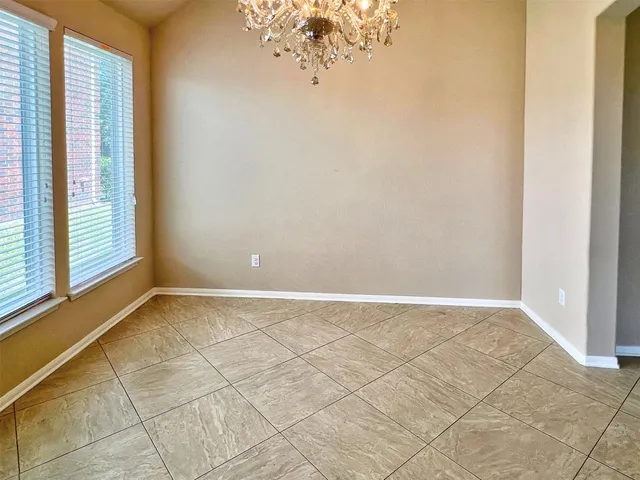 an empty room with a fireplace and chandelier