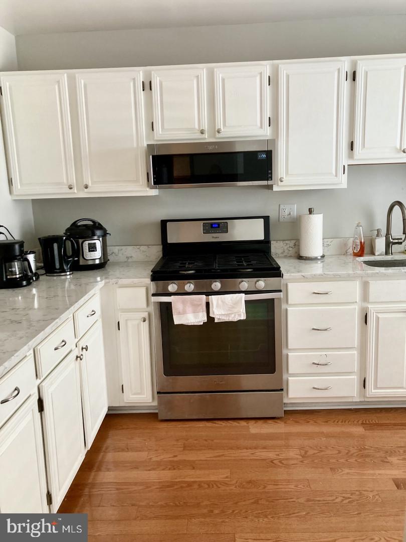 10087 Oakton Terrace Road Oakton, VA 22124 - Photo 6 of 13 a kitchen with granite countertop white cabinets and appliances