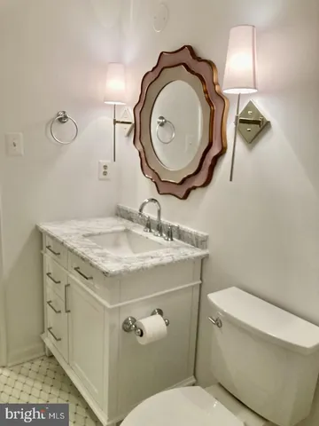 a bathroom with a granite countertop toilet sink and mirror