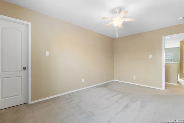 a view of an empty room with a ceiling fan