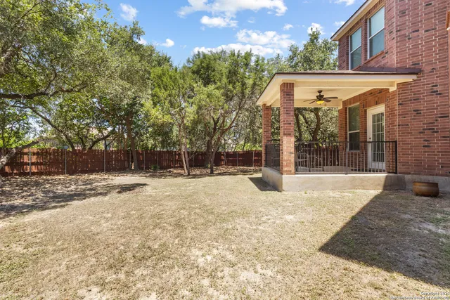 a view of a house with backyard and trees