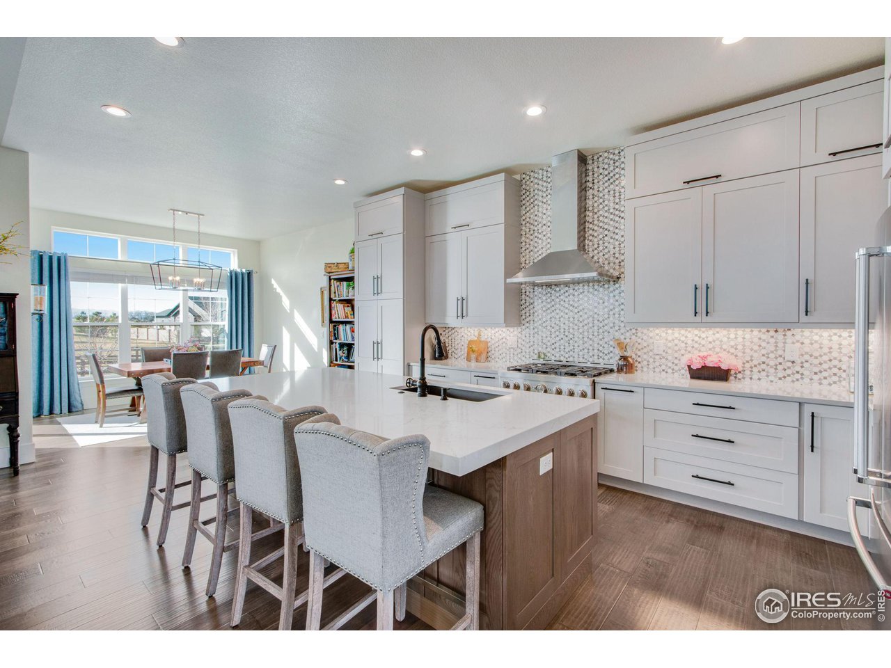6278 Foundry Court Timnath, CO 80547 - Photo 8 of 40 a kitchen with white cabinets appliances and chairs