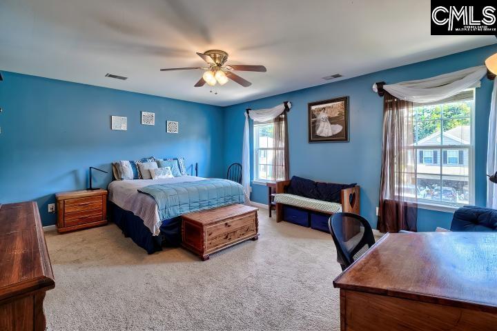 209 Eagle Pointe Drive Chapin, SC 29036 - Photo 30 of 40 a bedroom with a bed and a chandelier