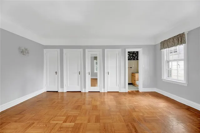 a view of an empty room with window and closet area