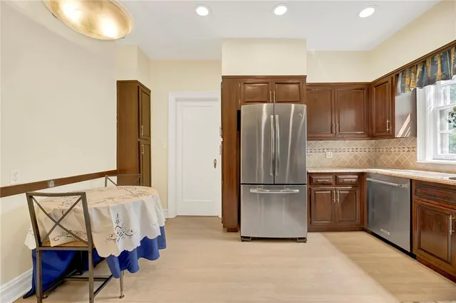 a kitchen with stainless steel appliances granite countertop a refrigerator and a stove