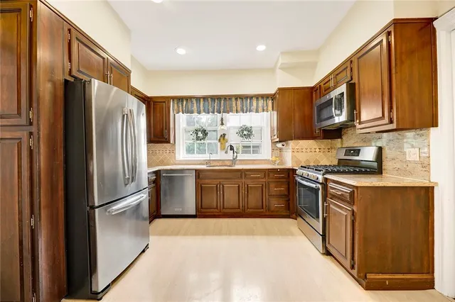 a kitchen with stainless steel appliances granite countertop a refrigerator stove top oven a sink and dishwasher