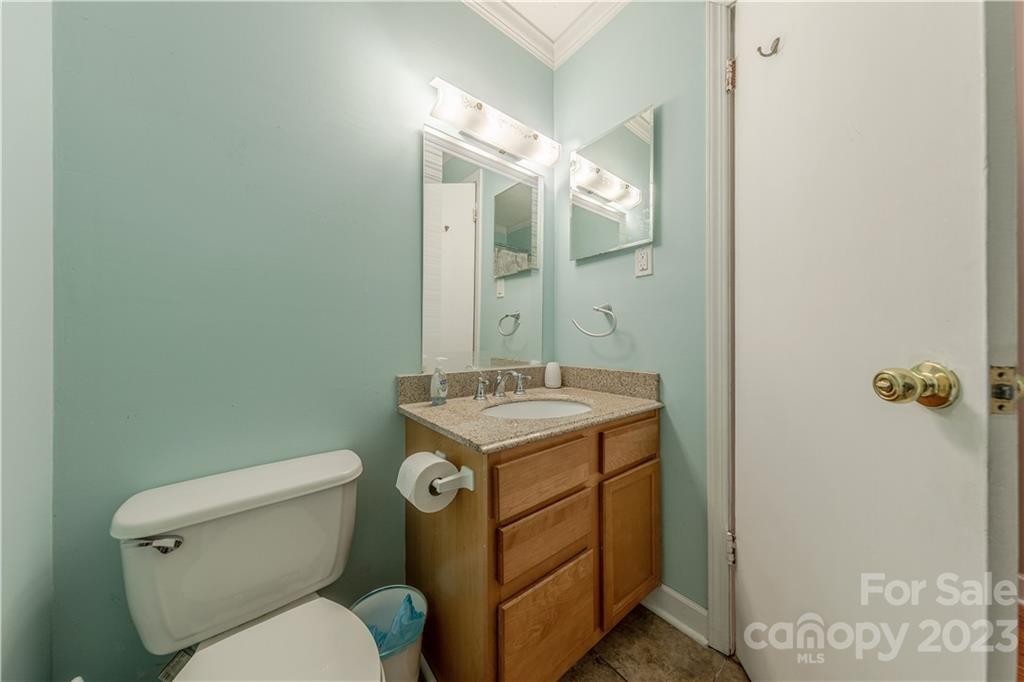 10672 Barberville Road Indian Land, SC 29707 - Photo 16 of 22 a bathroom with a granite countertop toilet a sink and mirror
