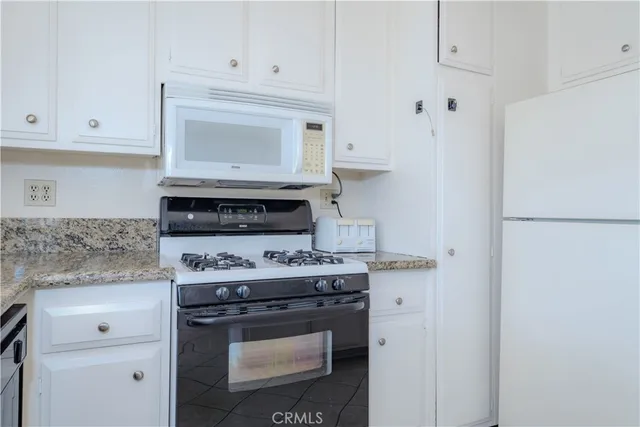 a stove top oven sitting inside of a kitchen