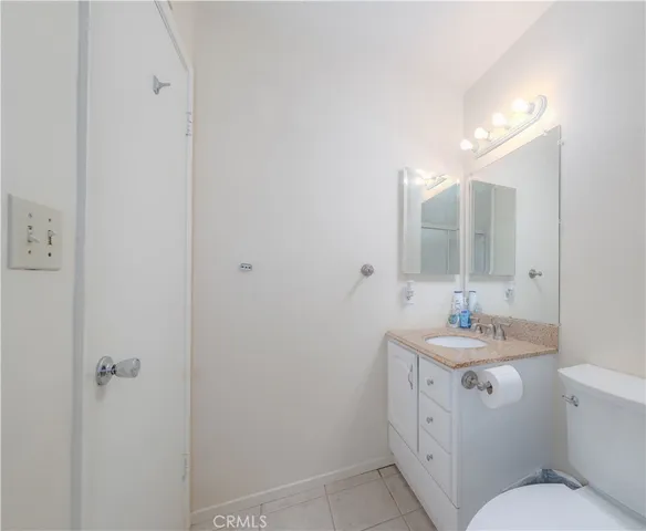 a bathroom with a sink toilet vanity and mirror