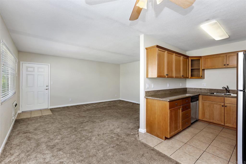 6602 Beadnell Way, Unit 26 San Diego, CA 92117 - Photo 13 of 25 a kitchen with stainless steel appliances granite countertop a stove and a sink